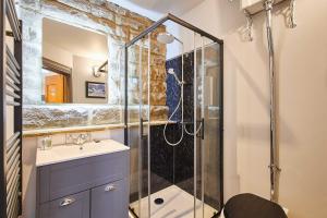 a bathroom with a shower with a sink and a mirror at The Churchside Well in Ravenscar