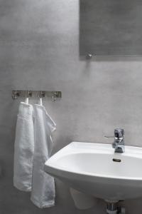 a bathroom with a white sink and two towels at Strömbäcks Vandrarhem in Umeå +23 photos