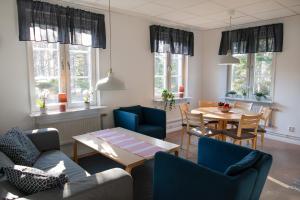 a living room with a couch and chairs and a table at Strömbäcks Vandrarhem in Umeå