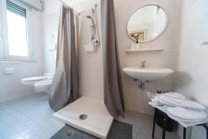 a white bathroom with a sink and a shower at LUDO Holiday House in Riccione +26 photos