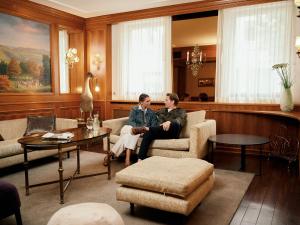 two women sitting on a couch in a living room at Hotel Krone ****S in Tübingen