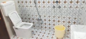 a bathroom with a toilet and a shower curtain at Pie Restuarant and HomeStay in Baihar