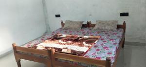 a bedroom with a bed with a floral bedspread at Pie Restuarant and HomeStay in Baihar