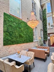 a patio with a table and chairs and a green wall at Hotel Concordia in Lund