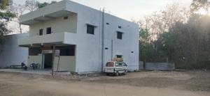 a white building with a van parked in front of it at Pie Restuarant and HomeStay in Baihar