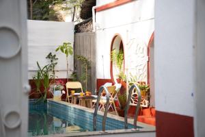 a pool with chairs and a table next to a building at Luxury 3BHK Pool Villa Near Beach Pondicherry in Pondicherry