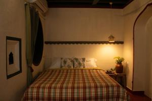 a bedroom with a bed with a plaid blanket at Luxury 3BHK Pool Villa Near Beach Pondicherry in Pondicherry +21 photos