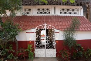 a gate to a house with a red roof at Luxury 3BHK Pool Villa Near Beach Pondicherry in Pondicherry