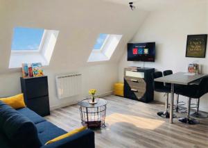 a living room with a blue couch and a tv at Appartement Centre Saint-Omer, Parking privé gratuit in Saint-Omer