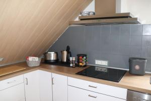a kitchen with white cabinets and a stove top oven at Siggis-Ferienwohnung in Bad Wildungen