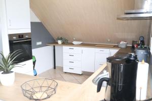 a kitchen with white cabinets and a counter top at Siggis-Ferienwohnung in Bad Wildungen
