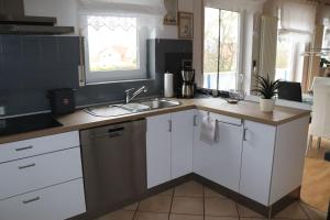 a kitchen with white cabinets and a sink at Siggis-Ferienwohnung in Bad Wildungen
