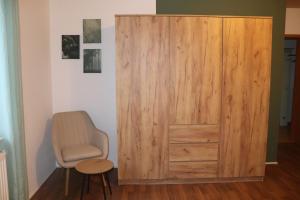 a large wooden door in a room with a chair at Siggis-Ferienwohnung in Bad Wildungen +7 photos