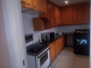 a kitchen with wooden cabinets and a stove top oven at B&P Guesthouse in Boksburg