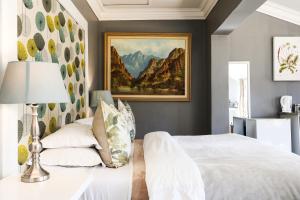 a bedroom with a bed and a painting on the wall at Upper House Boutique Guesthouse in Clarens