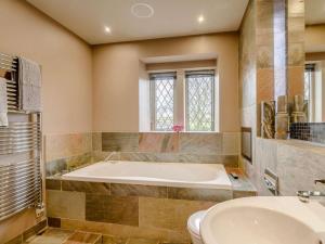 a bathroom with a tub and a toilet and a sink at 3 Bed in Halifax oc-90209 in Sowerby Bridge +15 photos