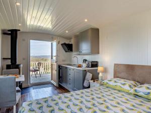 a bedroom with a bed and a kitchen with a balcony at 1 Bed in Bridport oc-90055 in Whitchurch Canonicorum