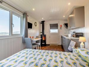 a bedroom with a bed and a kitchen with a stove at 1 Bed in Bridport oc-90055 in Whitchurch Canonicorum
