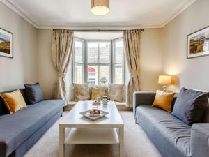 a living room with two blue couches and a table at 2 Bed in Harrogate oc-88933 in Pateley Bridge