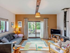 a living room with a couch and a tv at 3 Bed in Bude oc-trvvv in Poughill