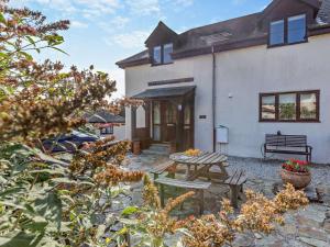 a patio with a picnic table in front of a house at 3 Bed in Bude oc-trvvv in Poughill