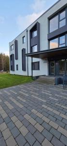a large white building with a parking lot at Kurzemes Pērle Beach Apartament - Albatross in Ķesterciems