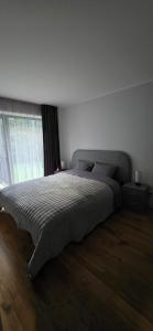 a bedroom with a large bed in front of a window at Kurzemes Pērle Beach Apartament - Albatross in Ķesterciems +33 photos