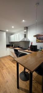 a kitchen with a wooden table in a kitchen at Kurzemes Pērle Beach Apartament - Albatross in Ķesterciems