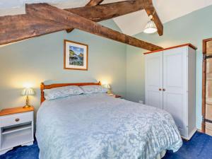 a bedroom with a large bed and wooden beams at 3 Bed in Bude oc-stafa in Poughill
