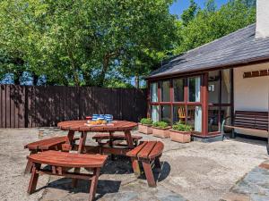 a picnic table and two benches in a backyard at 3 Bed in Bude oc-stafa in Poughill