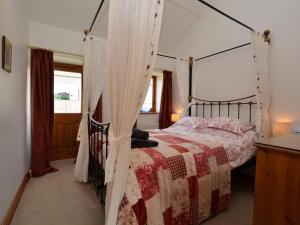 a bedroom with a bed with a canopy at 2 Bed in Sherborne oc-folki in Long Burton +14 photos
