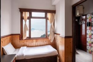 a bedroom with a bed and a window at The Di-Lac Retreat in Gangtok