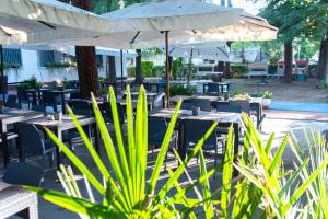 a patio with tables and chairs and an umbrella at LUDO Holiday House in Riccione