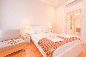 a white bedroom with a bed and a chair at FindMe InPorto Bonfim in Porto +27 photos