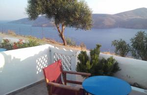 a balcony with chairs and a view of the water at Asvestoti ciel fish house in Astypalaia