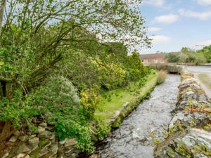 a stone wall next to a river with plants at 2 Bed in Harmby Nr Leyburn oc-g0136 in Hornby