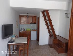 a kitchen with a table and a staircase in a room at Asvestoti ciel fish house in Astypalaia