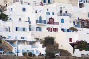 a white building with colorful doors on a hill at Asvestoti ciel fish house in Astypalaia