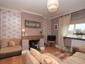 a living room with a couch and a fireplace at 3 Bed in Morpeth oc-cn137 in Amble