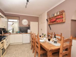 a kitchen with a wooden table and chairs at 3 Bed in Morpeth oc-cn137 in Amble +15 photos