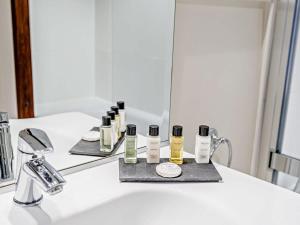 a bathroom with a sink with a mirror and some products at 1 Bed in Dulverton oc-lbard in Dulverton +24 photos