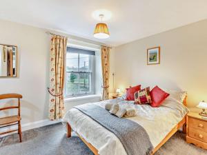a bedroom with a bed with red pillows and a window at 2 Bed in Hexham oc-50500 in Bellingham