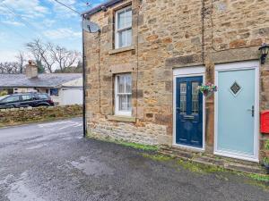 a brick house with a blue door on a street at 2 Bed in Hexham oc-50500 in Bellingham +11 photos