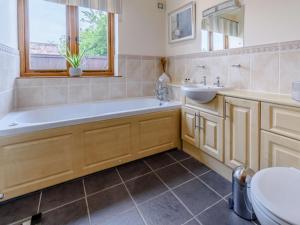 a bathroom with a tub and a sink and a toilet at 3 Bed in York oc-83264 in High Catton