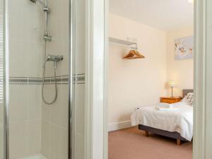 a bathroom with a walk in shower next to a bed at 3 Bed in Harrogate oc-hh056 in Harrogate +15 photos