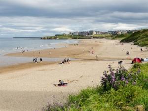 a group of people on a beach near the ocean at 5 Bed in Tynemouth oc-cn125 in Tynemouth