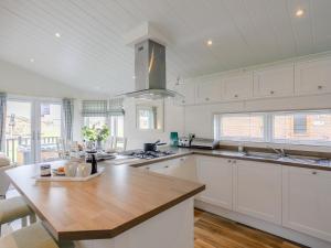 a kitchen with white cabinets and a wooden counter top at 2 Bed in Bridlington oc-79429 in Sewerby