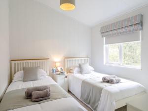 two beds in a room with white walls and a window at 2 Bed in Bridlington oc-79429 in Sewerby