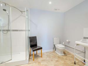 a bathroom with a toilet and a black chair at 3 Bed in Yeovil oc-htorv in Castle Cary +11 photos
