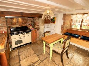 a kitchen with a table and a stove top oven at 4 Bed in Godshill oc-ic034 in Godshill +8 photos